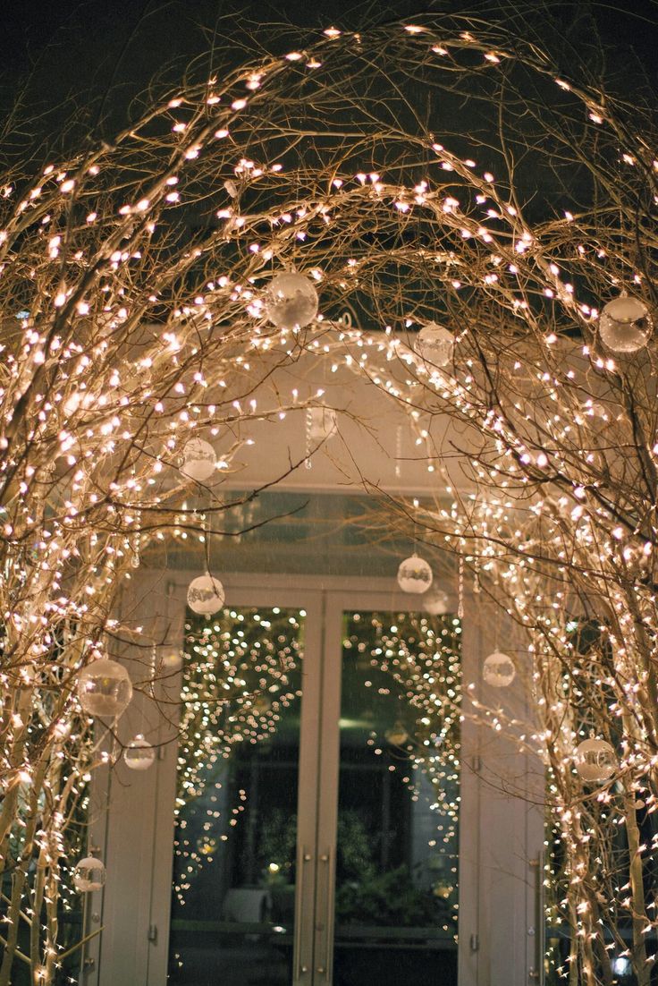 an archway decorated with christmas lights and ornaments