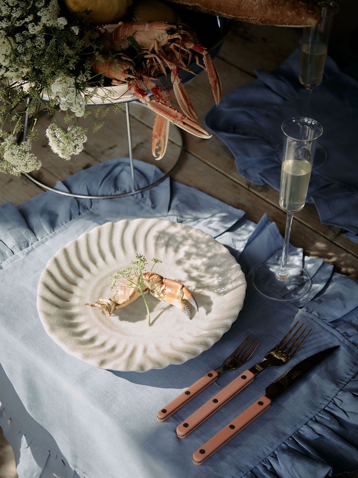 a white plate topped with food on top of a blue table cloth next to utensils