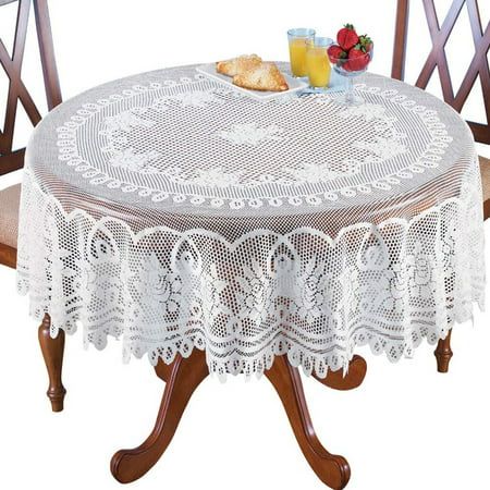 a table with two chairs and a white lace doily on top of it, next to a basket of fruit