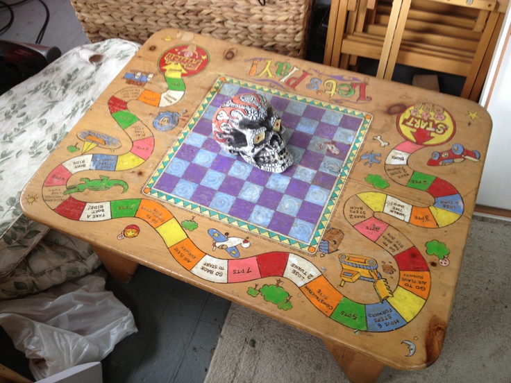 a wooden table with a game board on it and a skull sitting on the top