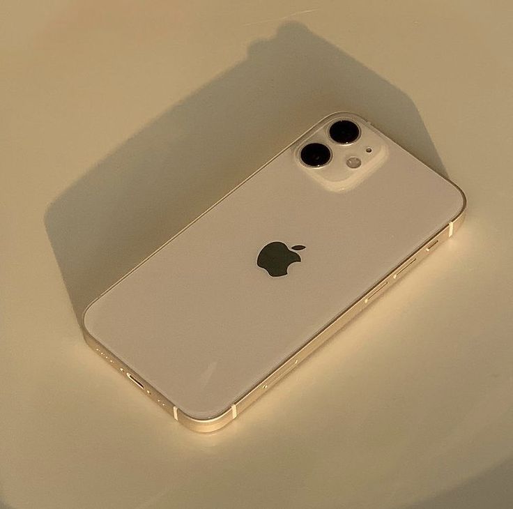 an iphone is sitting on a table with its back facing the camera and it's light shining down