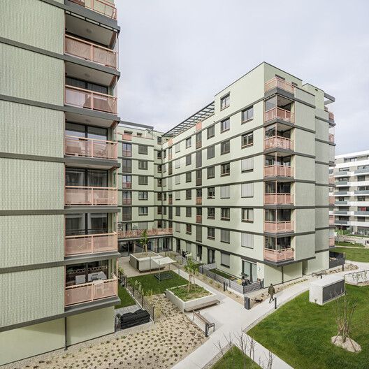 an apartment building with several balconies on the second floor