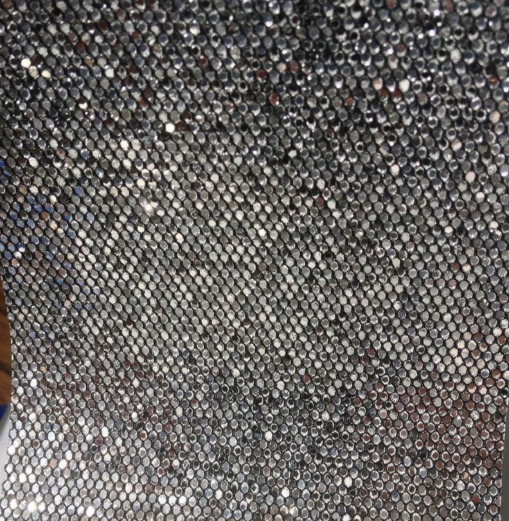 a close up view of a silver sequined surface