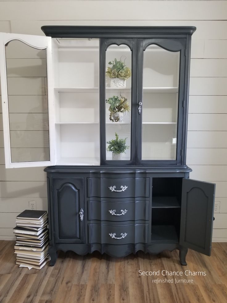 an old china cabinet painted black with white trim