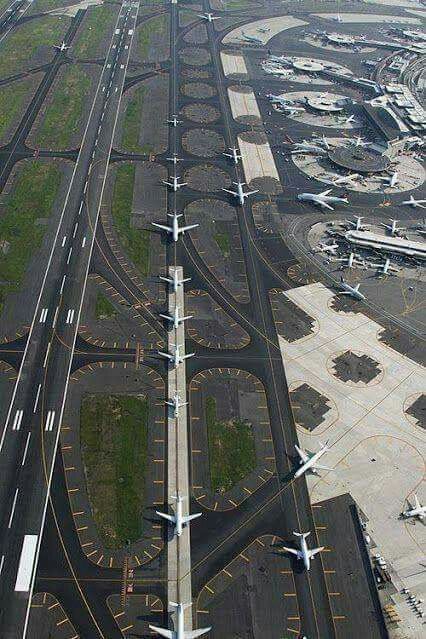 an aerial view of several airplanes parked on the tarmac at an airport with multiple lanes