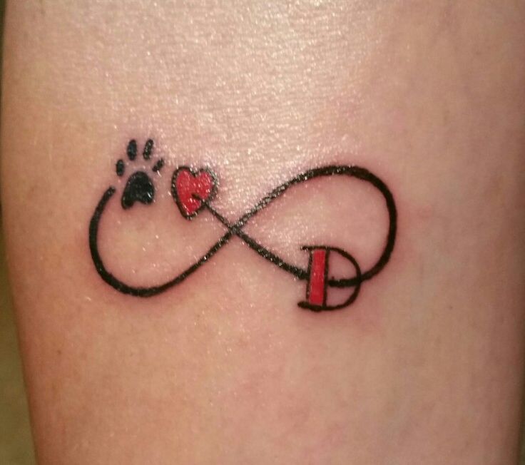 a dog's paw and heart tattoo on the thigh with an infinite love knot