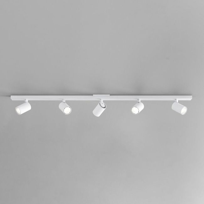 four lights are hanging from the ceiling in an empty room with gray walls and flooring