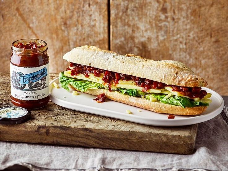 a sandwich sitting on top of a white plate next to a jar of ketchup