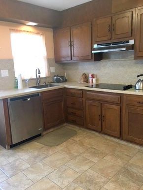 a kitchen with wooden cabinets and tile flooring