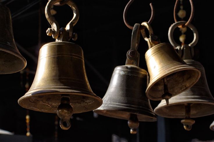 four bells hanging from the ceiling in a room