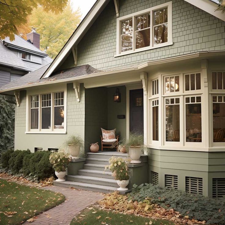 a house with green paint and white trim on the front door is shown in autumn