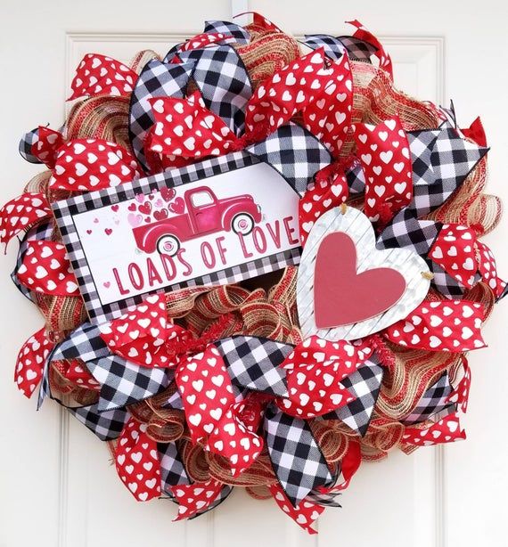 a red and white wreath with a sign that says, loads of love on it