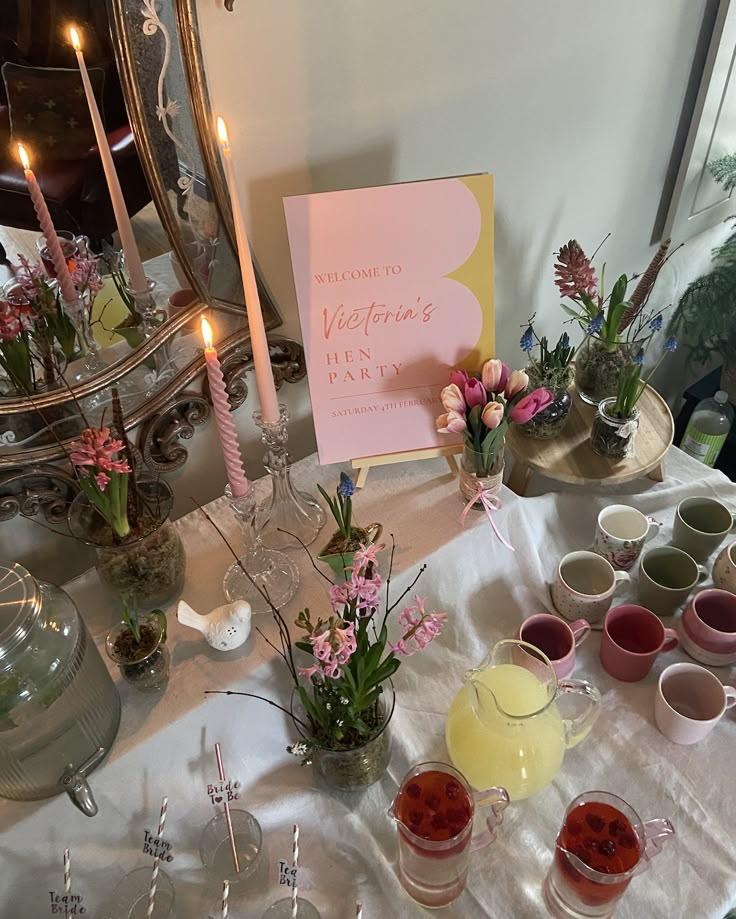 a table topped with lots of cups and saucers next to a sign that says valentine's day