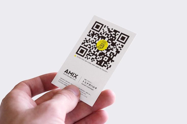 a hand holding a white business card with a qr code on it