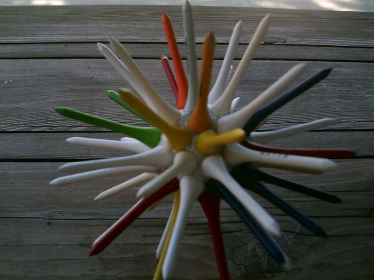 a multicolored toothbrush holder sitting on top of a wooden table