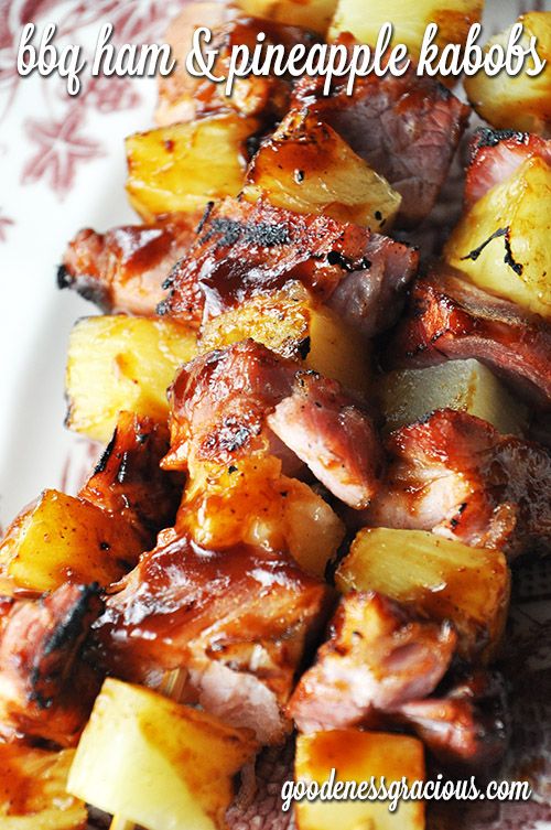 some food is on a white plate with red and pink flowers in the background that says boohan's pineapple kabobs