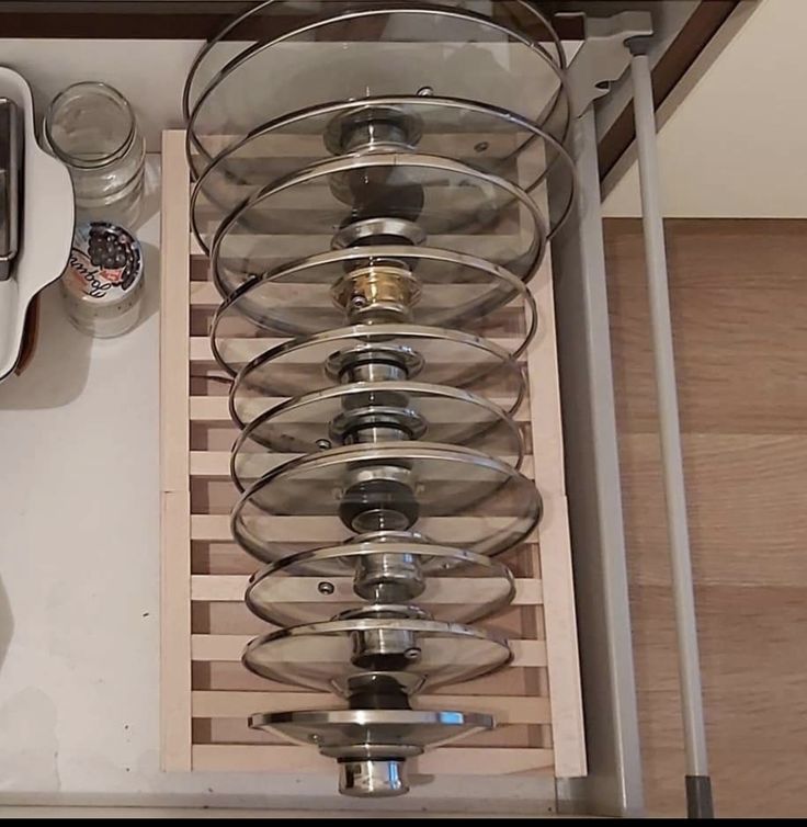 a kitchen counter top with lots of pots and pans sitting on it's bottom shelf