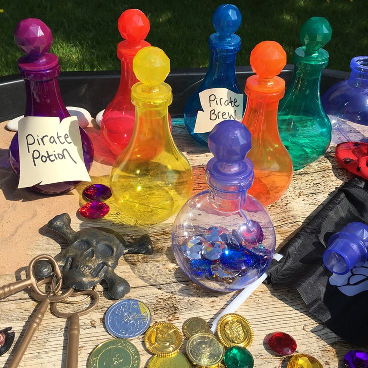 several different colored glass bottles and other items on a table with price tags attached to them