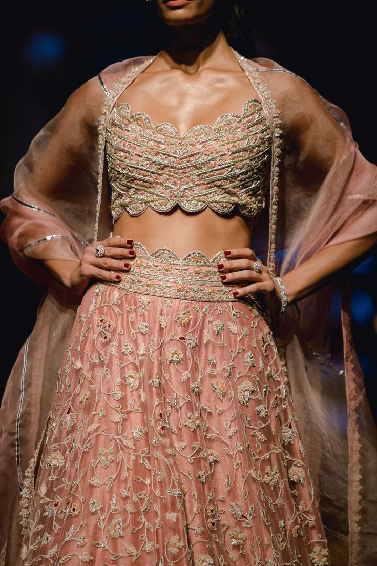 Editor's Note This set includes a peach lehenga paired with a matching dupatta and scallop hem blouse. The lehenga features intricate embroidery, while the net dupatta adds a delicate touch to the outfit. The blouse is designed to complement the lehenga and is also adorned with intricate embroidery. Color: Peach Fabric: Net; raw silk Components: Lehenga, blouse and dupatta Occasion: Engagement Disclaimer: Product color may slightly vary due to photographic lighting sources or your monitor settin Peach Reception Dress With Sheer Dupatta, Designer Wear Organza Lehenga With Lace Work, Bollywood Style Lehenga With Lace Work For Reception, Organza Lehenga With Lace Work For Reception, Designer Bollywood Lehenga With Lace Work, Semi-stitched Peach Lehenga With Sheer Dupatta, Designer Peach Lehenga With Intricate Embroidery, Peach Lehenga With Sheer Dupatta, Semi-stitched, Designer Lace Work Lehenga With Traditional Drape