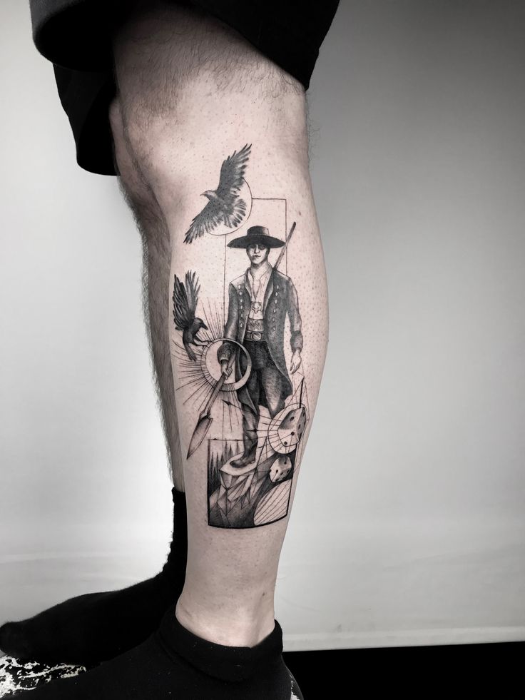 a man's leg with a black and white tattoo design on it, which has a bird flying over him