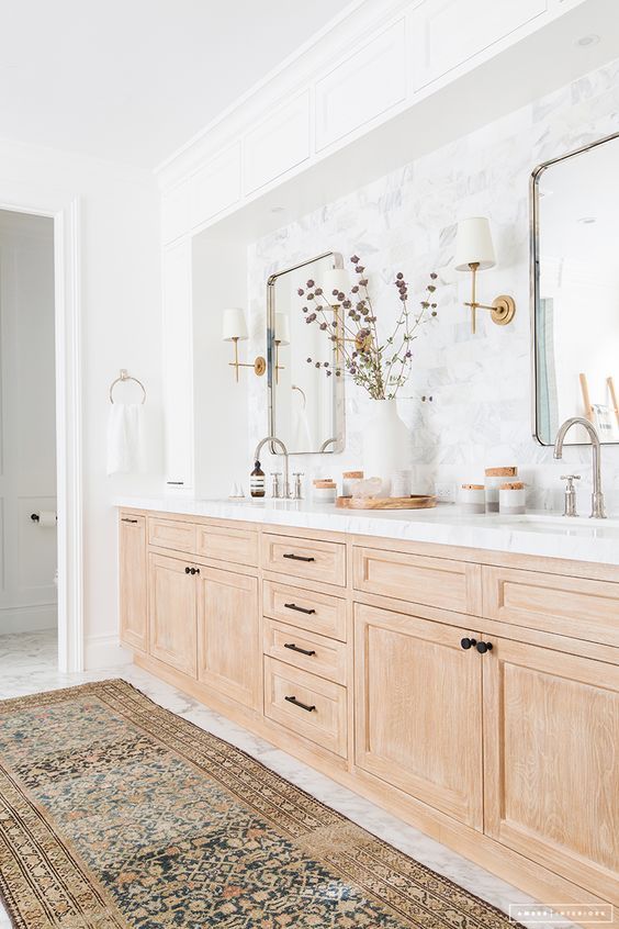 a large bathroom with double sinks and mirrors on the wall, along with a rug