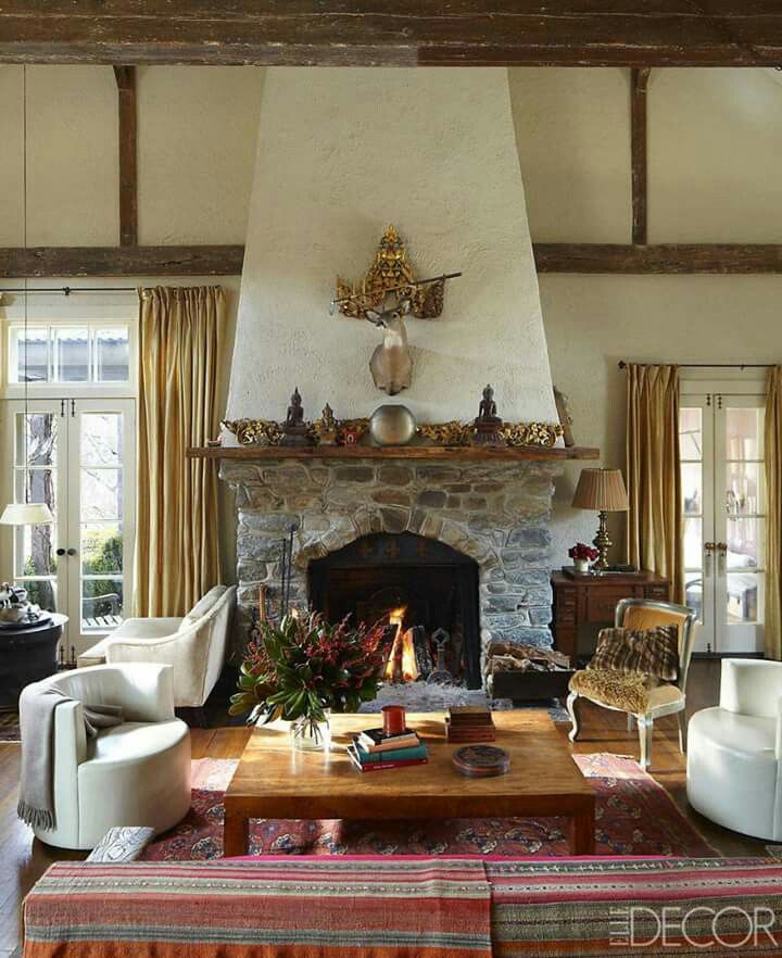 a living room filled with furniture and a fire place in the middle of a room