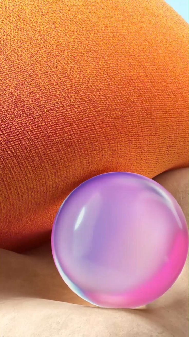 an orange and pink object sitting on top of a white table next to a pillow