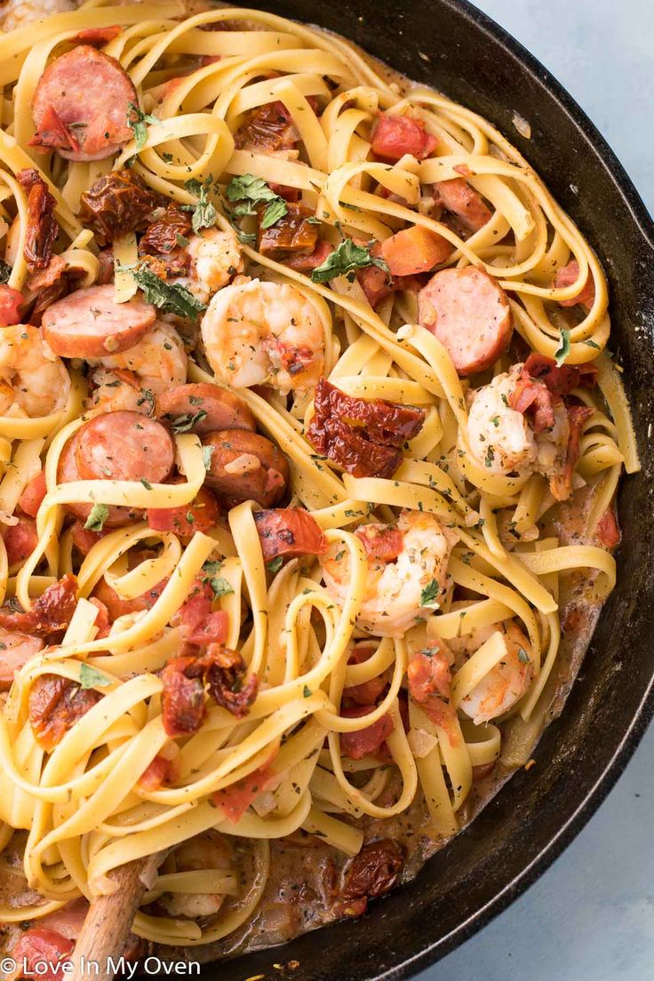 a skillet filled with pasta and shrimp