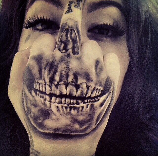 a woman with her face painted to look like a skeleton is holding her hand up to her mouth