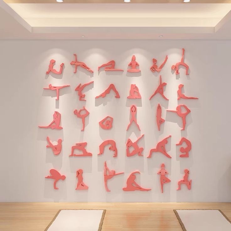 a room with yoga mats on the floor and various pink objects mounted to the wall