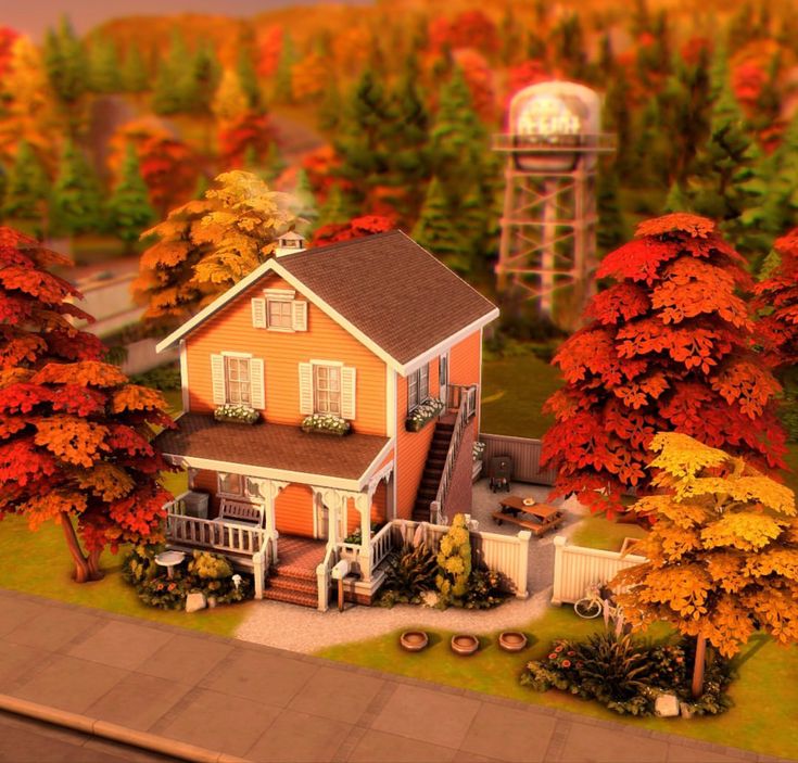 a small house surrounded by trees with fall foliage around it and a water tower in the background