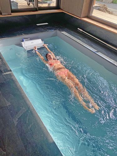 a woman swimming in a pool with a remote controller