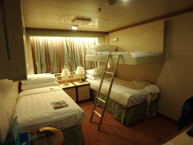 a bunk bed room with two beds and a ladder to the top of it in front of a window