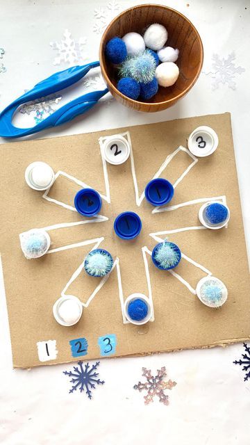 a table topped with blue and white dishes next to snowflakes on top of paper