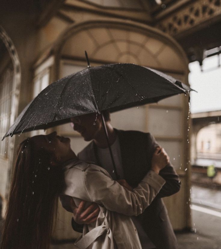 a couple kissing under an umbrella in the rain