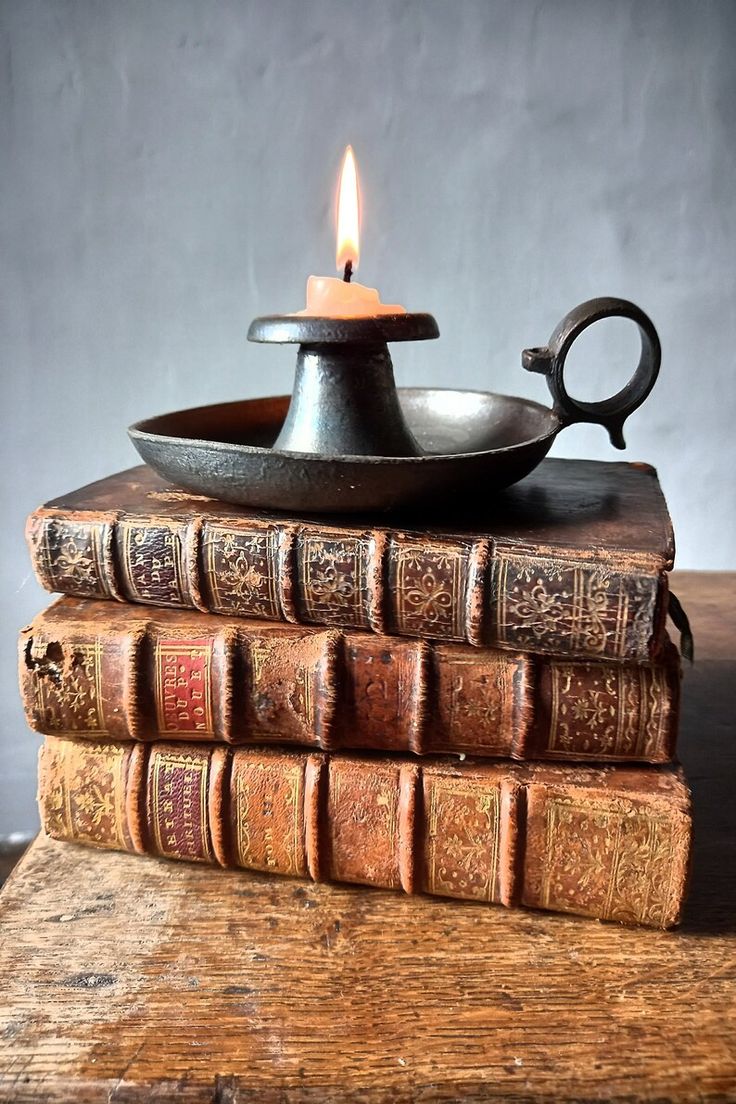 an old book with a candle on top