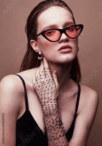 a beautiful woman wearing red glasses posing for the camera with her hands on her face