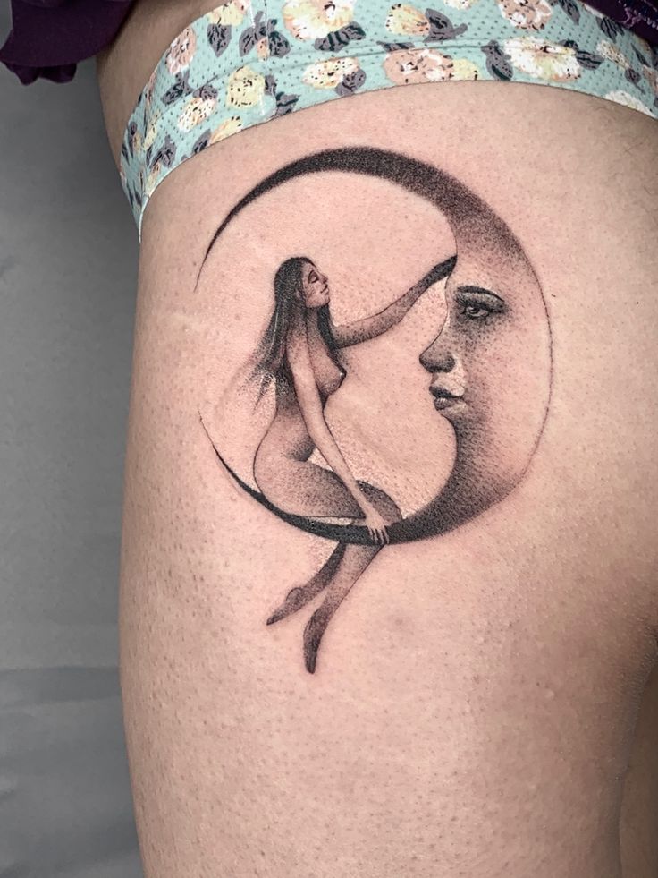 a woman's thigh with a crescent moon tattoo on the side of her leg