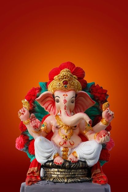 an elephant statue sitting on top of a table next to a red wall and orange background