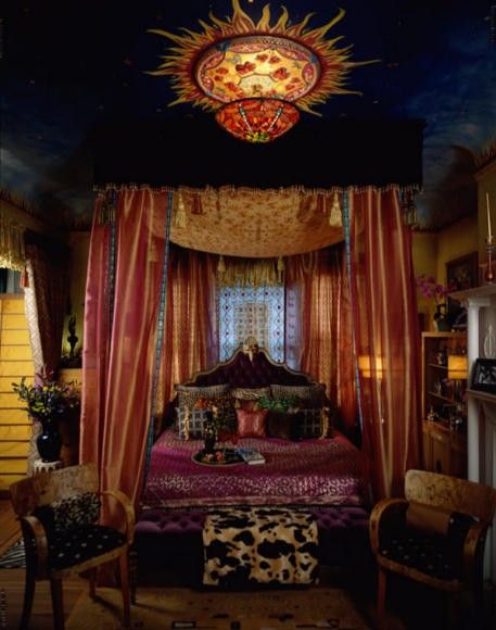 a bedroom with a canopy bed covered in curtains and drapes on top of it