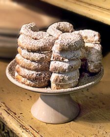 a white plate filled with powdered sugar covered donuts on top of a wooden table