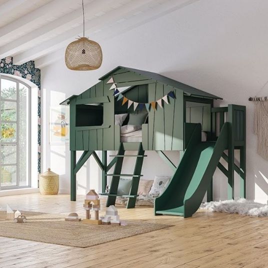 a child's bedroom with a green slide and bunk bed in the corner, next to a window