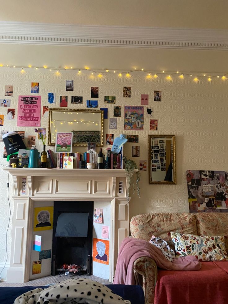 a living room with a fire place and pictures on the wall above it's fireplace