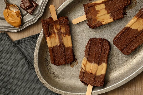 chocolate and caramel popsicles on a metal plate