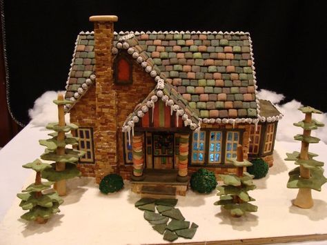 a gingerbread house with trees and bushes around it