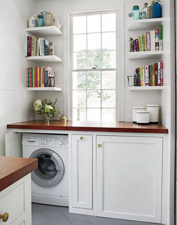 a washer and dryer in a room with bookshelves on the wall