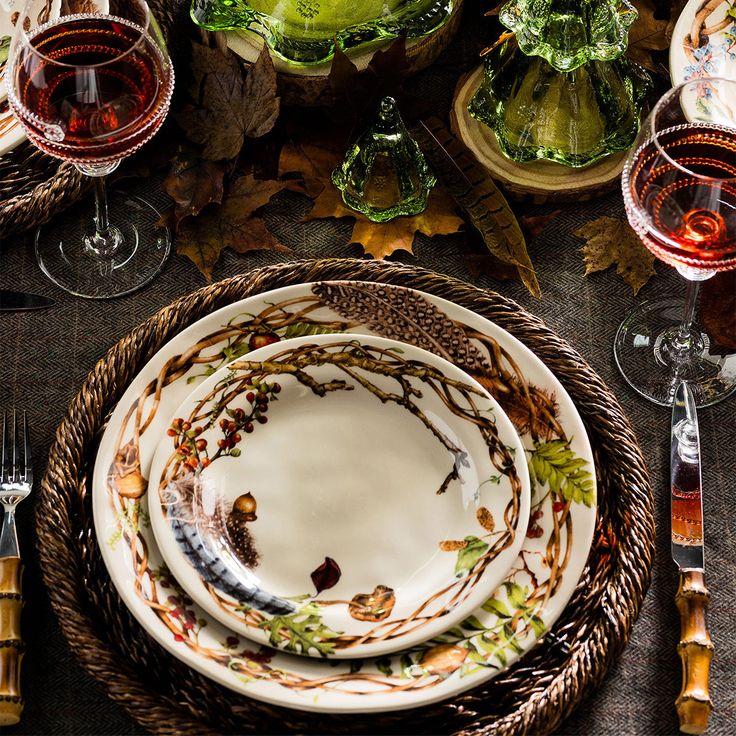 the table is set with dishes and wine glasses