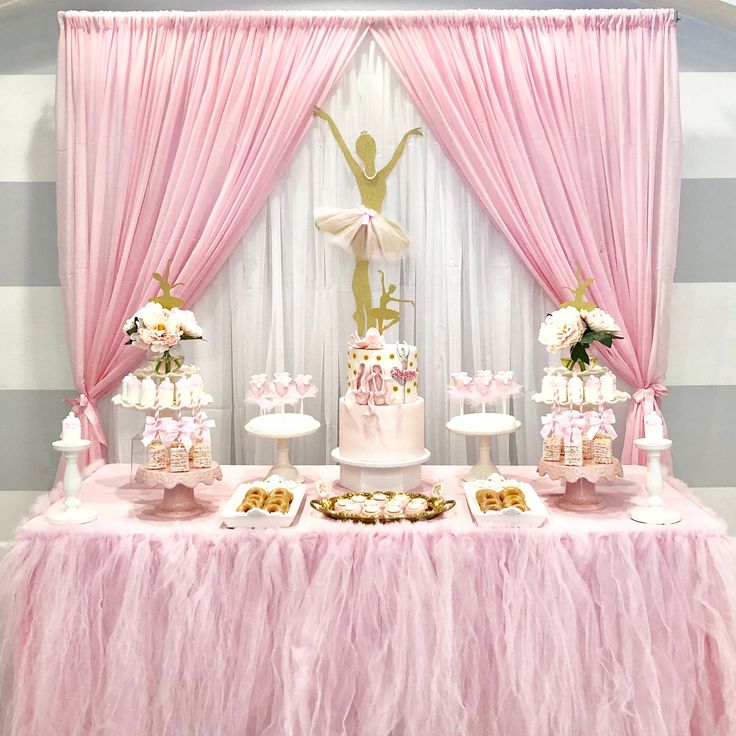 a table with pink and white desserts on top of it in front of a striped wall