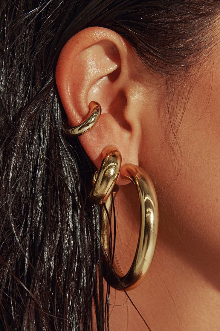 Any outfit, every day, all occasions. Sculpted in a two-inch arc, our 18K gold filled hoops are the style that unites true hoop girls and those who just dabble in the art. Wear solo or alongside other hoops in a graduating stack. Jewelry Collection Handcrafted in Brazil 18k Gold Filled Thickness: 7mm Diameter: 2" Weight: 0.55 oz Waterproof Hypoallergenic.#jewelrylover #handcraftedjewelry #jewelryinspiration #jewelrydesign #jewelryobsessed #jewelryoftheday #jewelrygoals #jewelryfashion #jewelrytrends Gold Hoop Earring Stack, Gold Chunky Earrings, Stack Jewelry, Chunky Gold Earrings, Gold Statement Jewelry, Chunky Gold Jewelry, Thick Gold Hoop Earrings, Thick Gold Hoops, Dope Jewelry Accessories