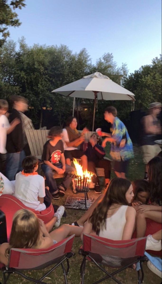 a group of people sitting around a fire pit